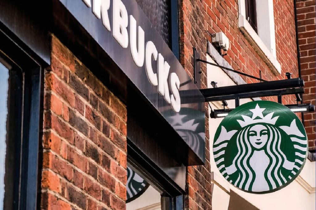 Mental and Physical Availability example: Exterior view of a Starbucks coffee shop with a prominent green and white logo on a brick building.